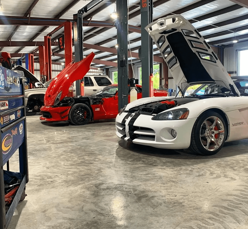 Cars in garage with hoods open