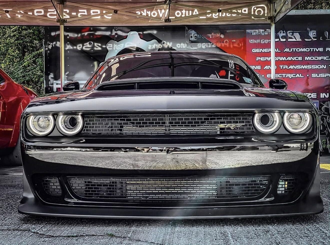 Front view of a black Dodge Challenger in a garage.