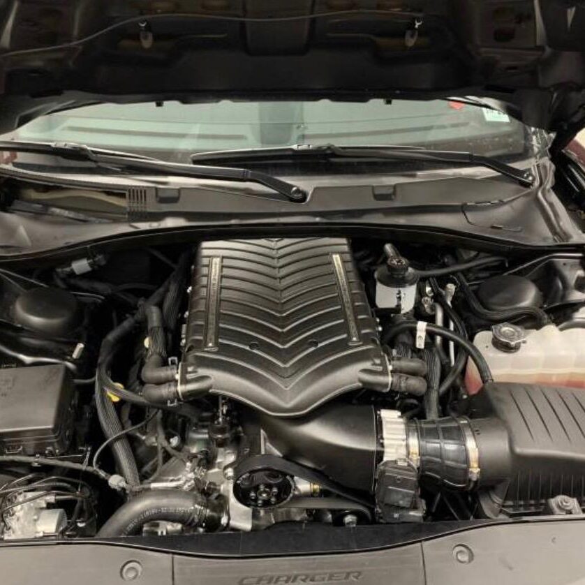 Close-up of a modern car engine with visible air intake and components.